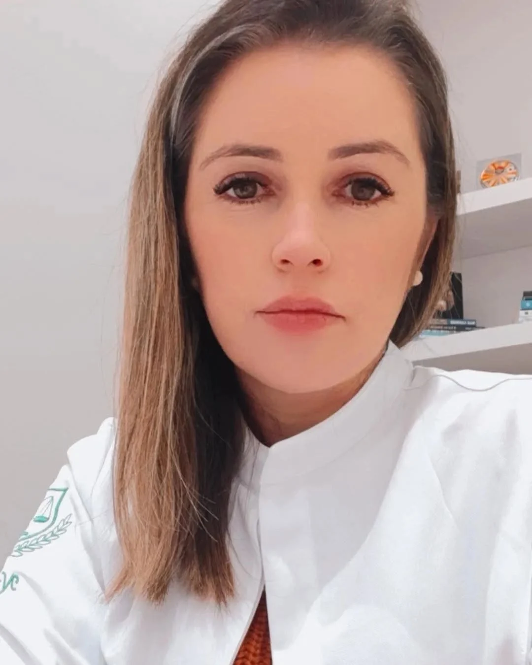 Gisleide de jaleco, em close, no consultório